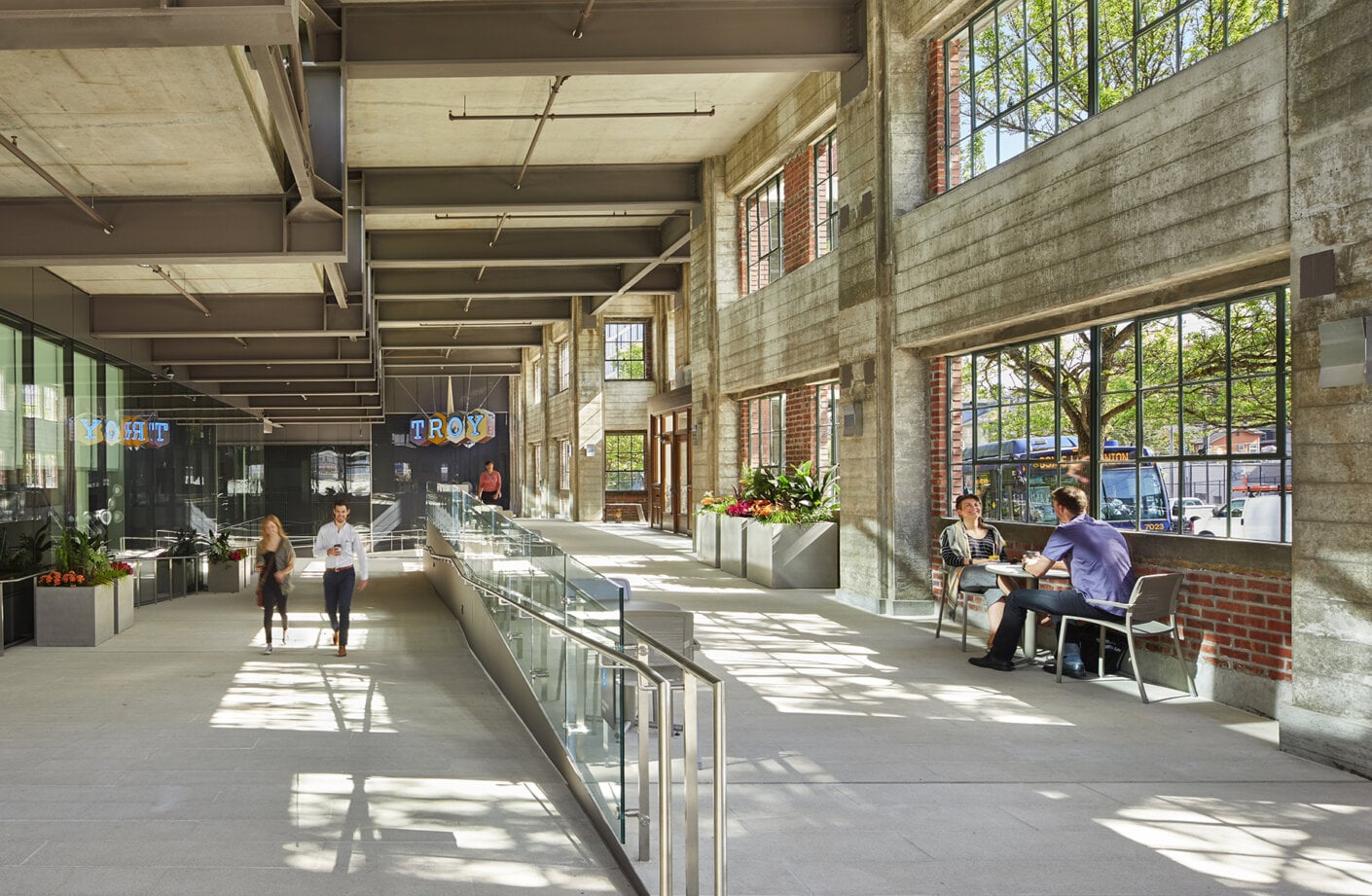 Covered cross-block connection inside historic Troy Laundry facade with business men/women walking through