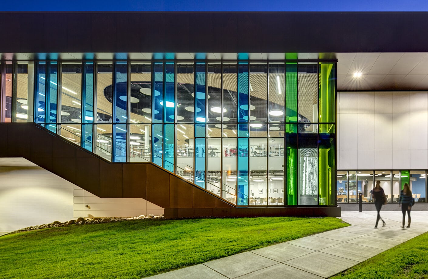 Exterior of the Wood Center at dusk with views to the cafeteria inside.