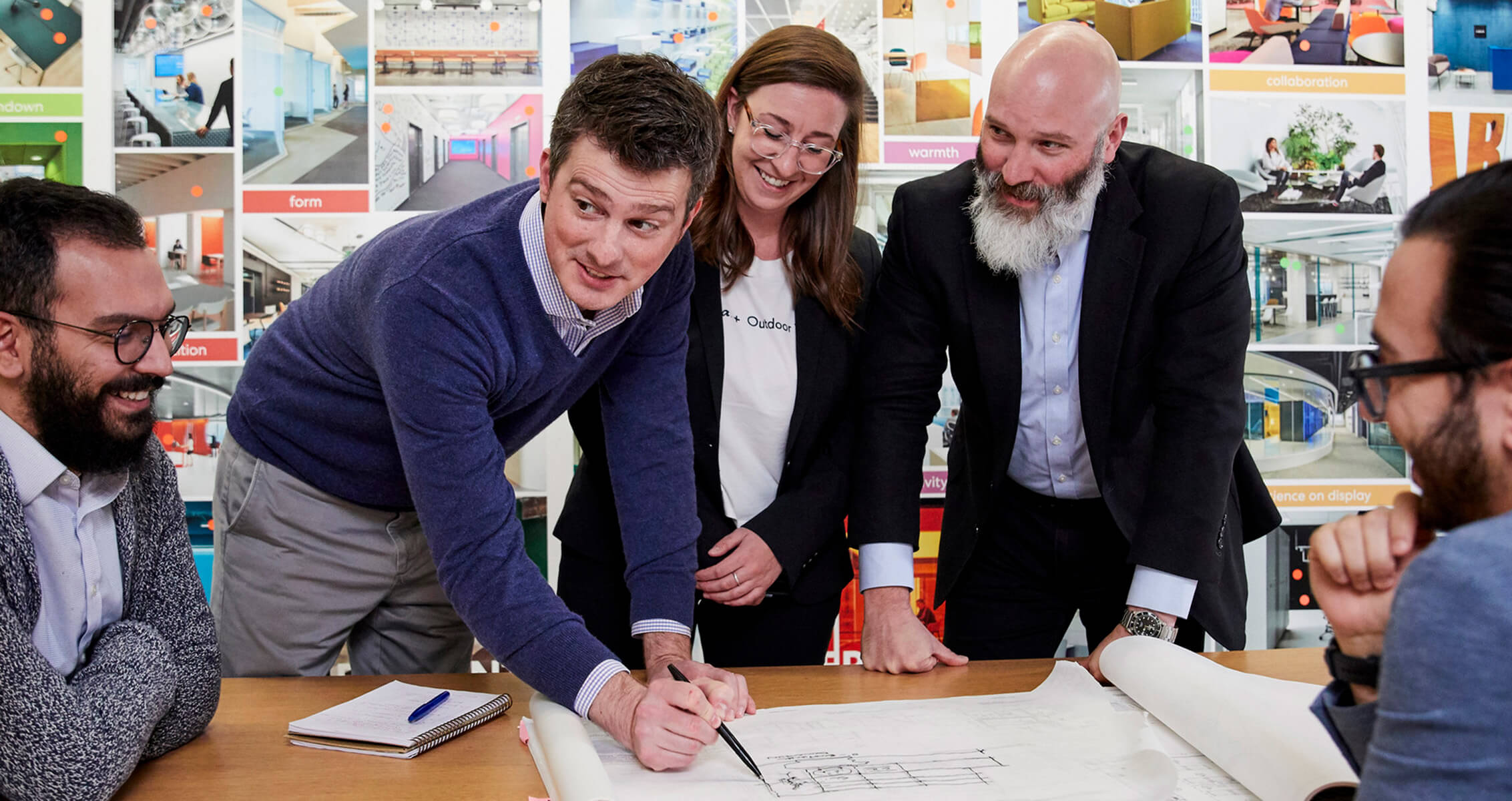 four people collaborating over an architectural plan