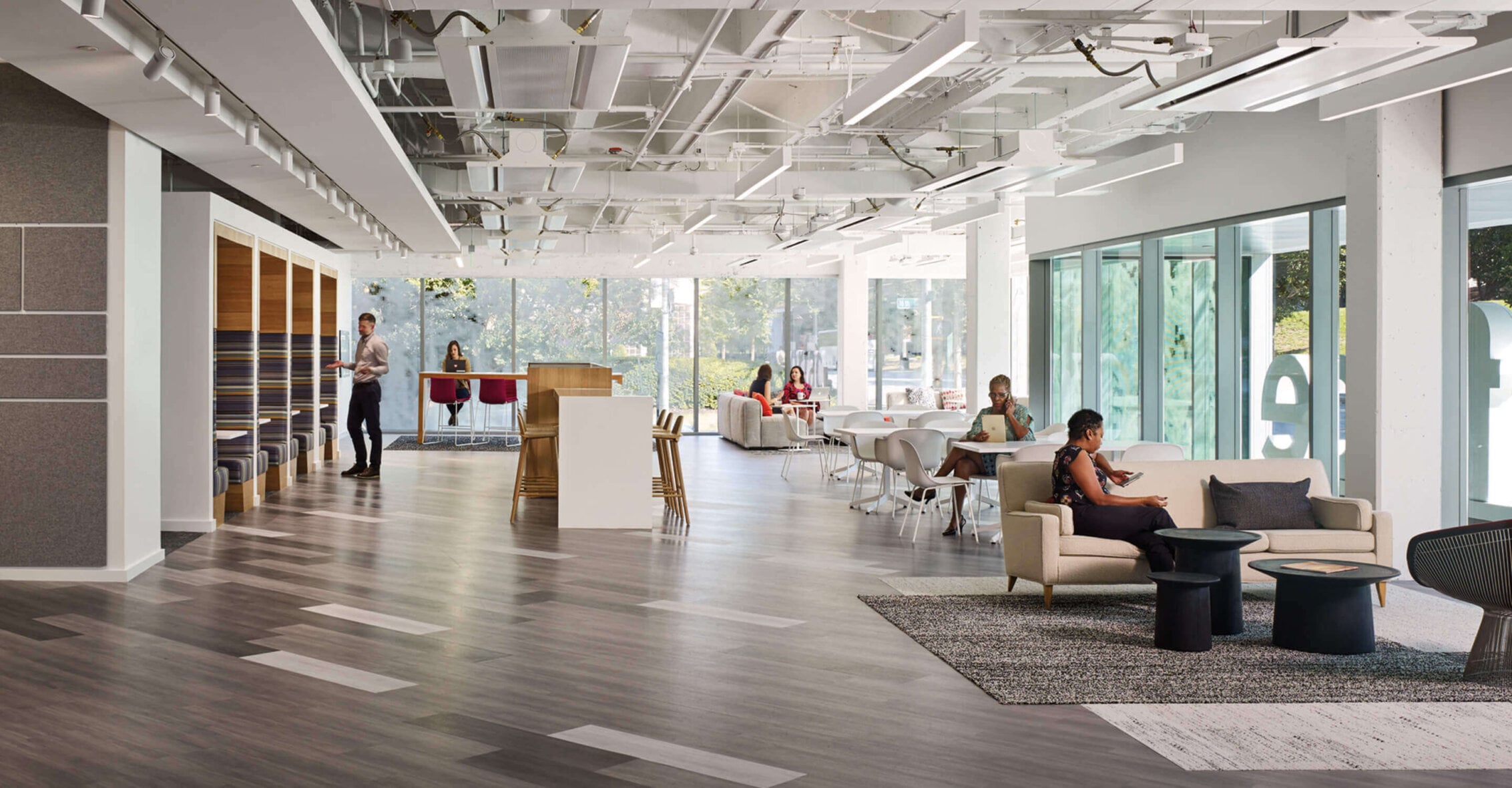 Photo showing office area filled with natural light from floor-to-ceiling windows