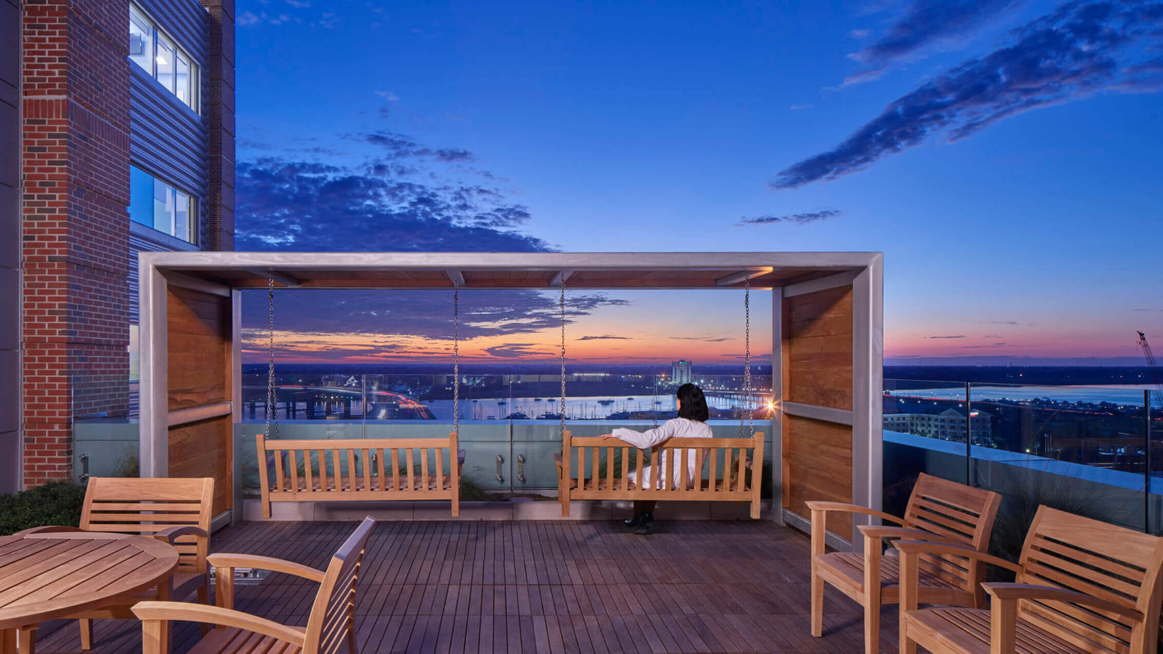 Photo of a doctor taking a break on an outdoor terrace adjacent to a hospital staff lounge