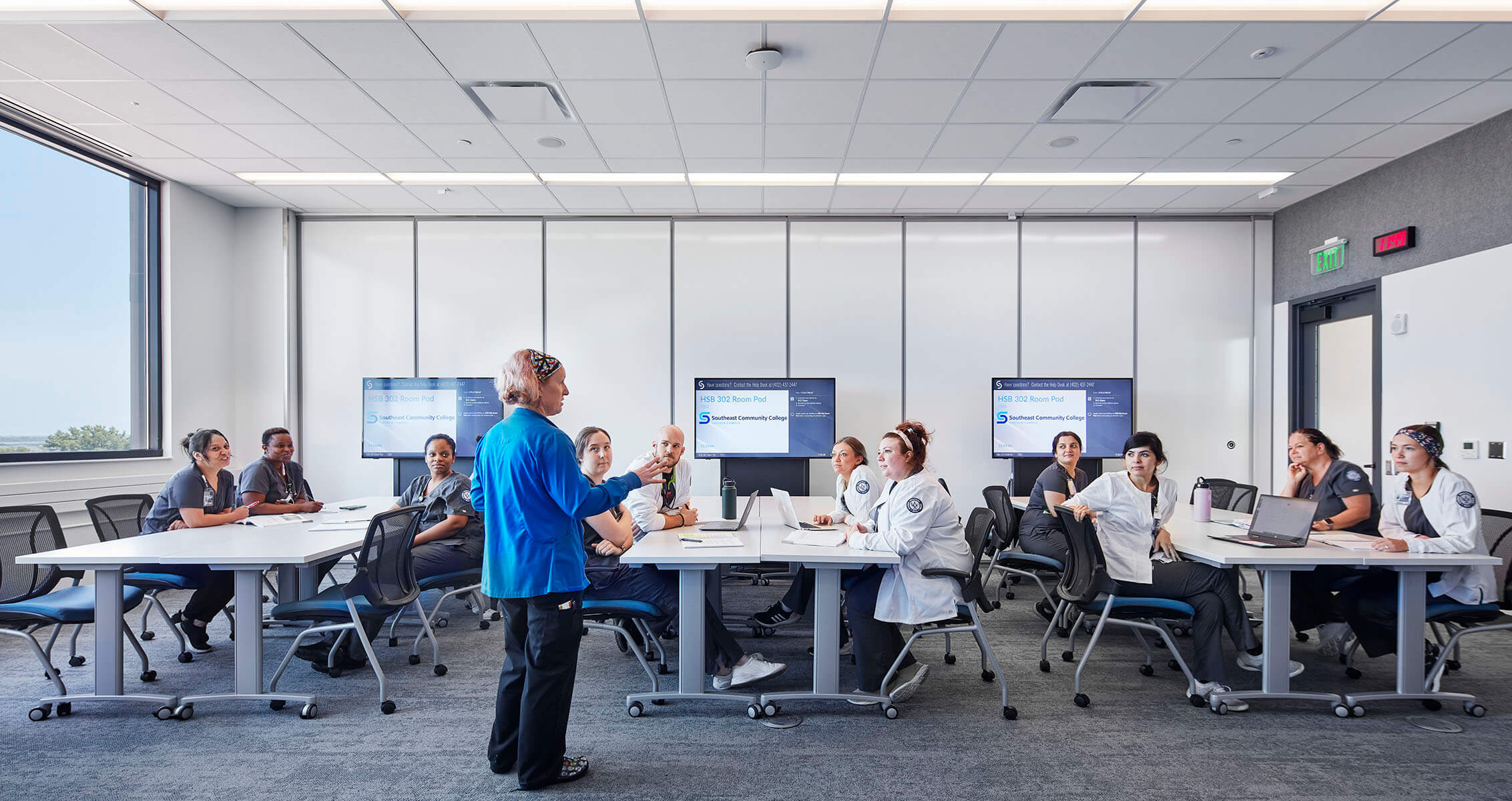 Photo of students in different healthcare professional degree programs listening to a lecture at a healthcare education building.