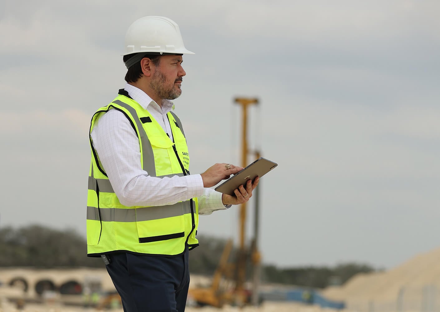 Omar stands on site in a hard hat