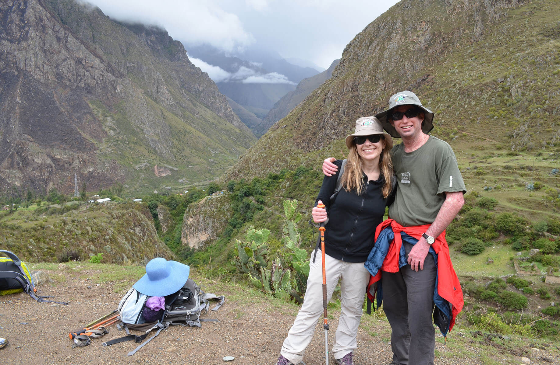two people hugging on a mountain overlook