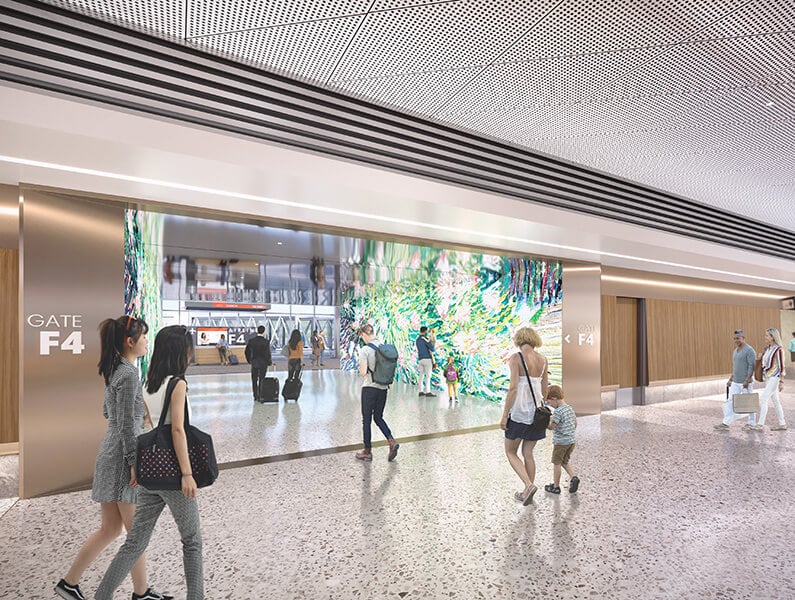 A rendering of a passageway in Terminal F illuminated by floor-to-ceiling digital displays on each wall