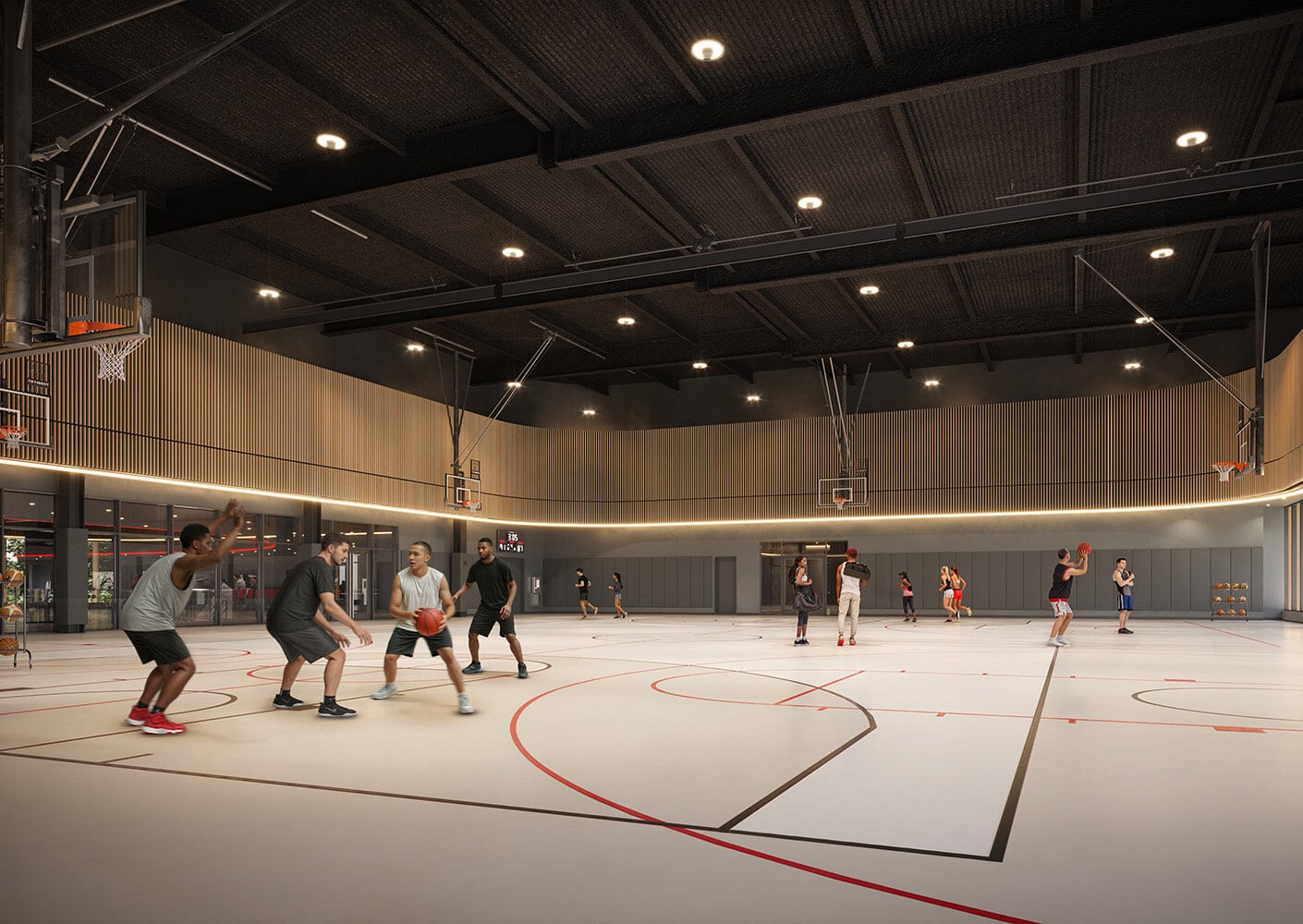 Basketball players engaged in a game inside a gym with wooden accents and bright lighting, featuring multiple basketball hoops and a spacious court.