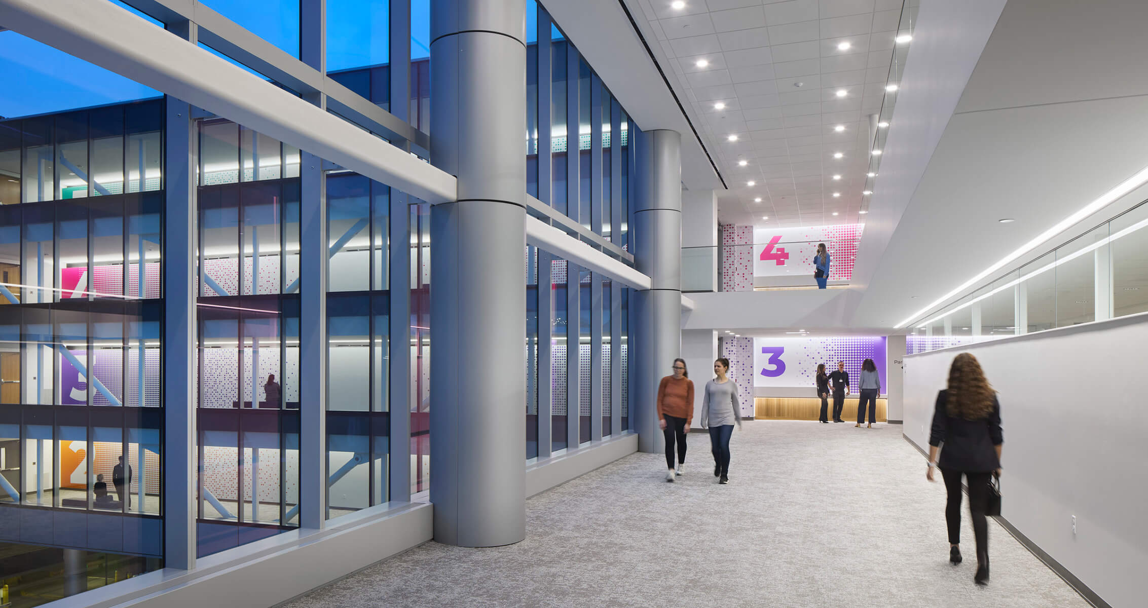 Hospital interior showing wayfinding signage and large windows with a view to other floors in the building