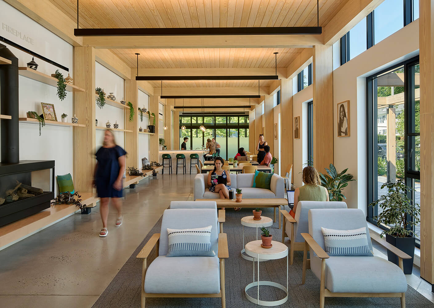Modern cafe and lounge of community squash center with people relaxing and socializing in a cozy, well-lit space.