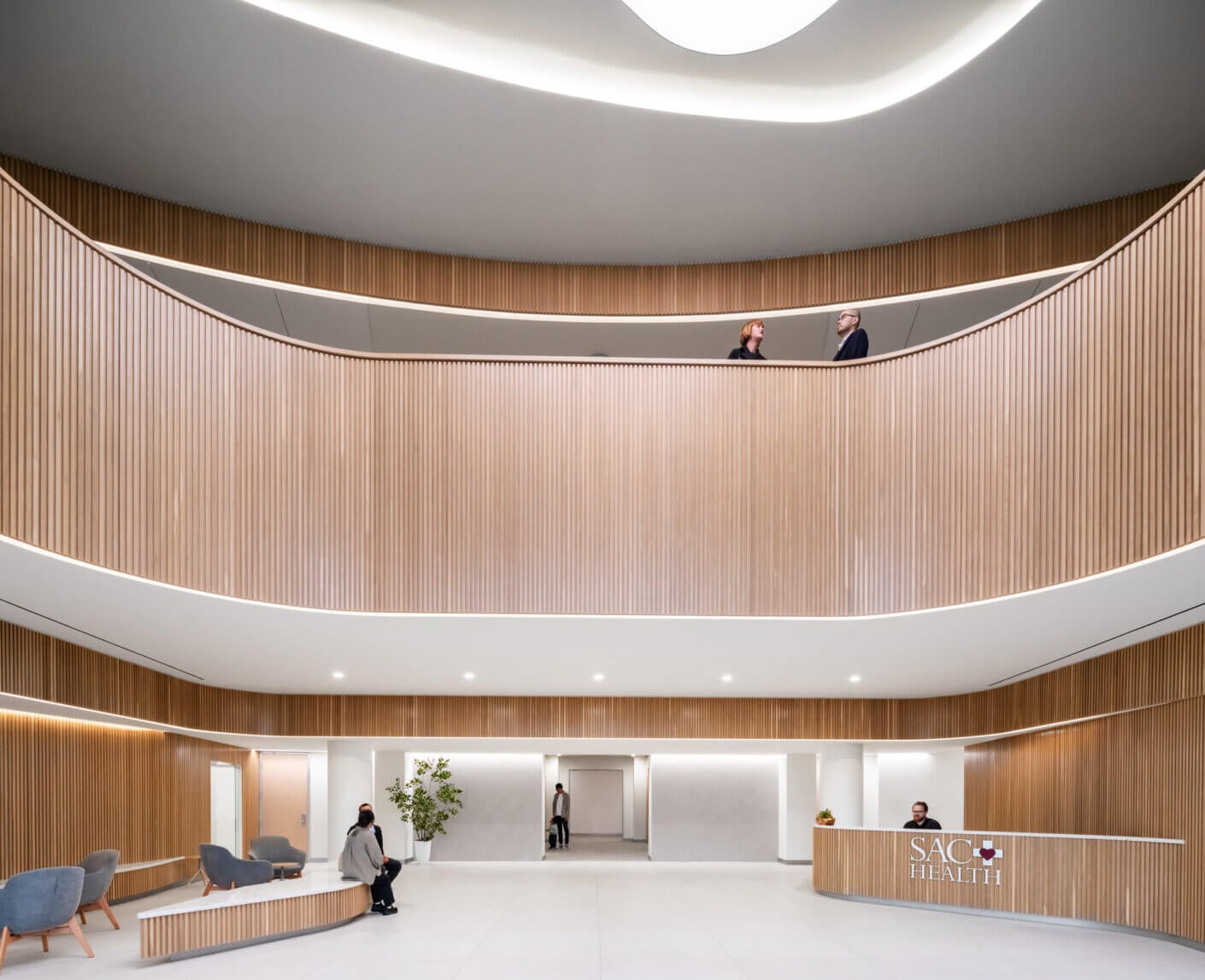 Modern healthcare lobby with curved wood design and seating area.
