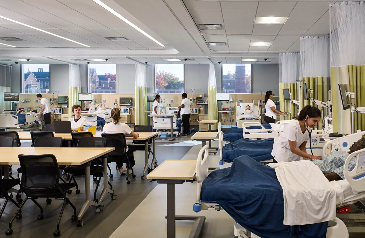 Medical training room with students and patient simulators.