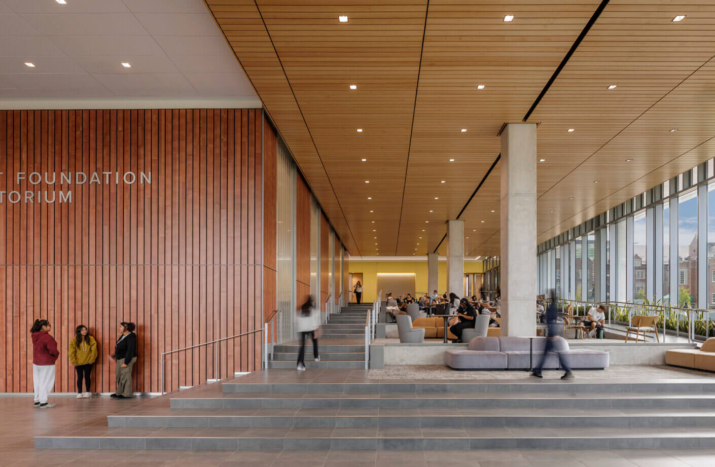 Modern university atrium with people interacting and studying in open space.