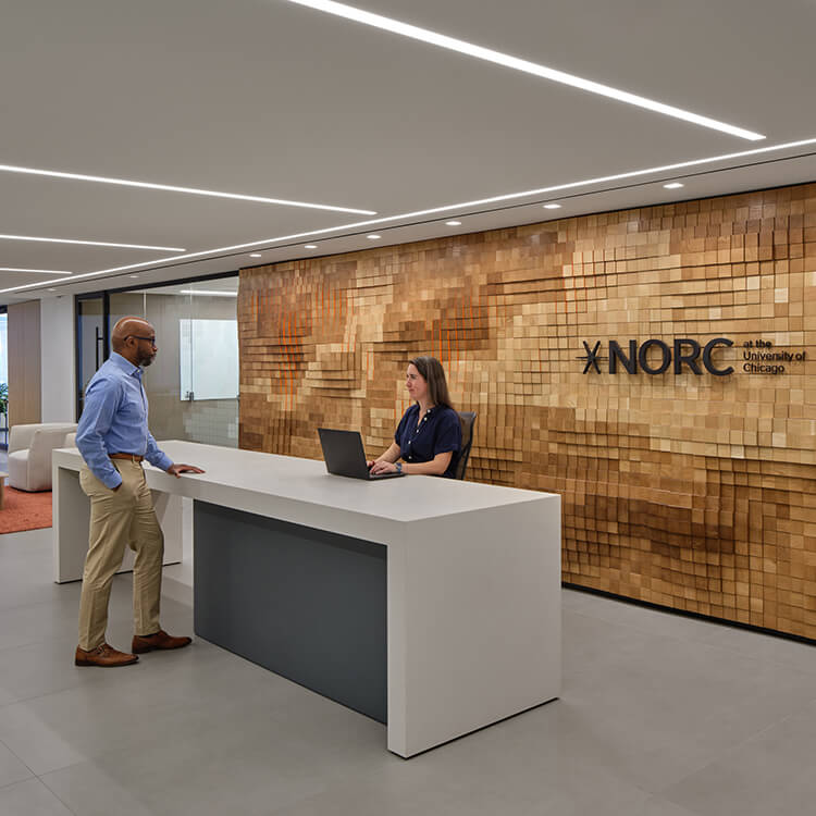 Modern office reception at NORC with two people interacting.