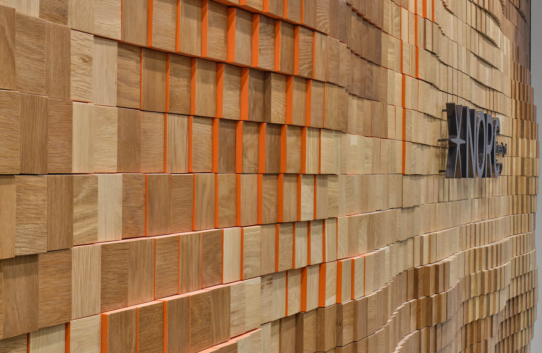 Wooden squares with orange accents create a textured, modern wall design.