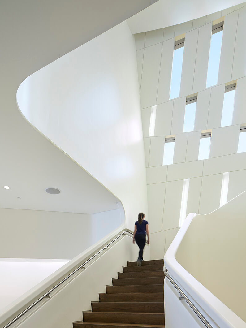 Modern architectural staircase with woman ascending.
