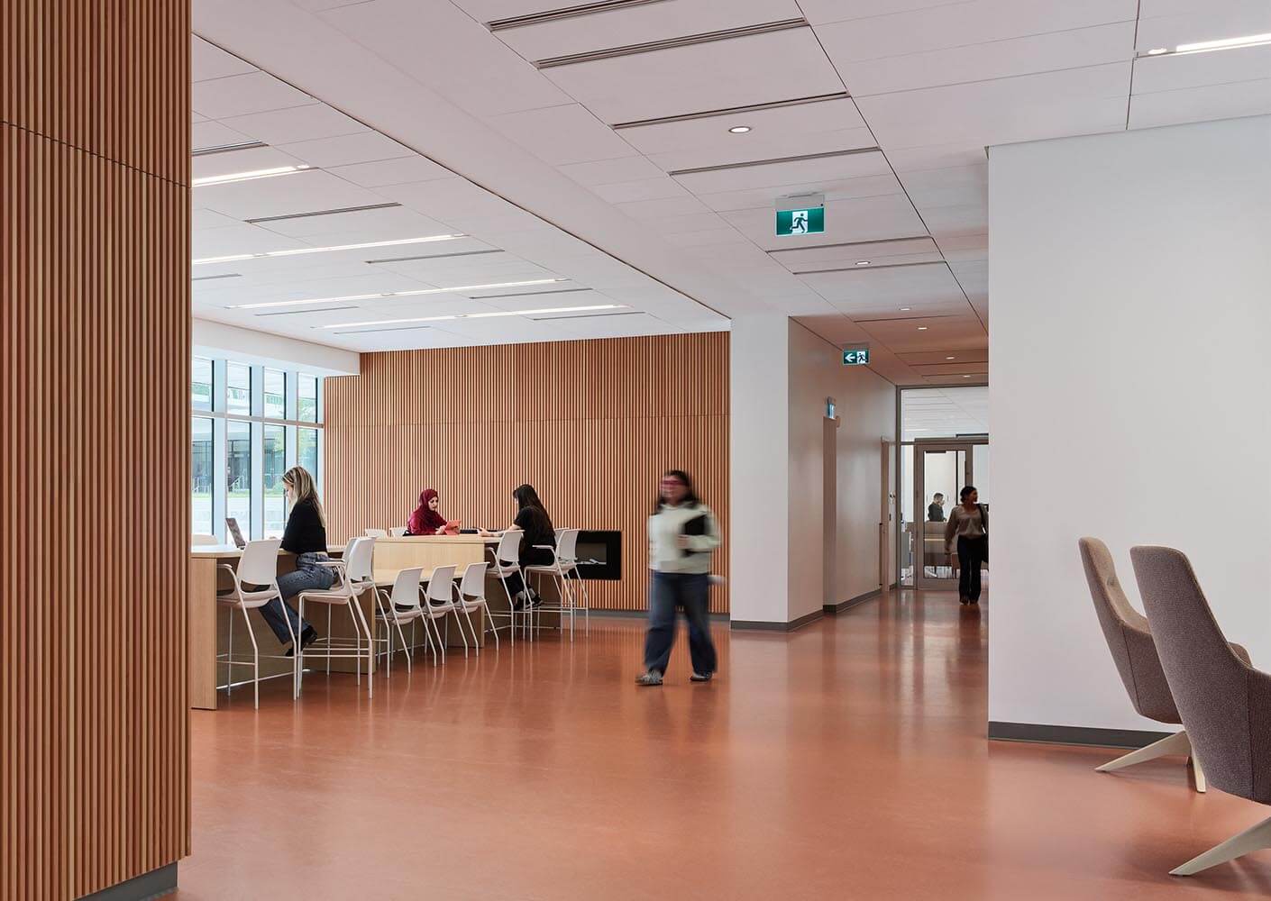 Modern office lounge with people working at tables.