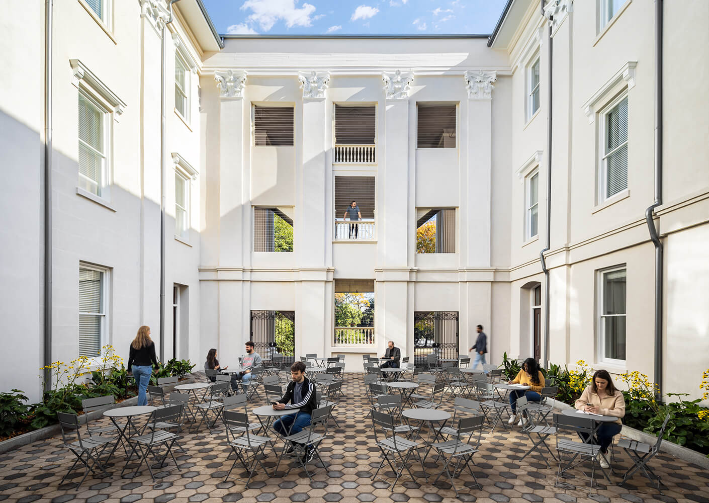 Modern courtyard with people enjoying outdoor seating arrangements.