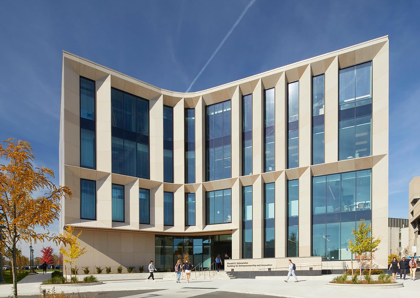 Modern building facade with large windows under a clear blue sky.