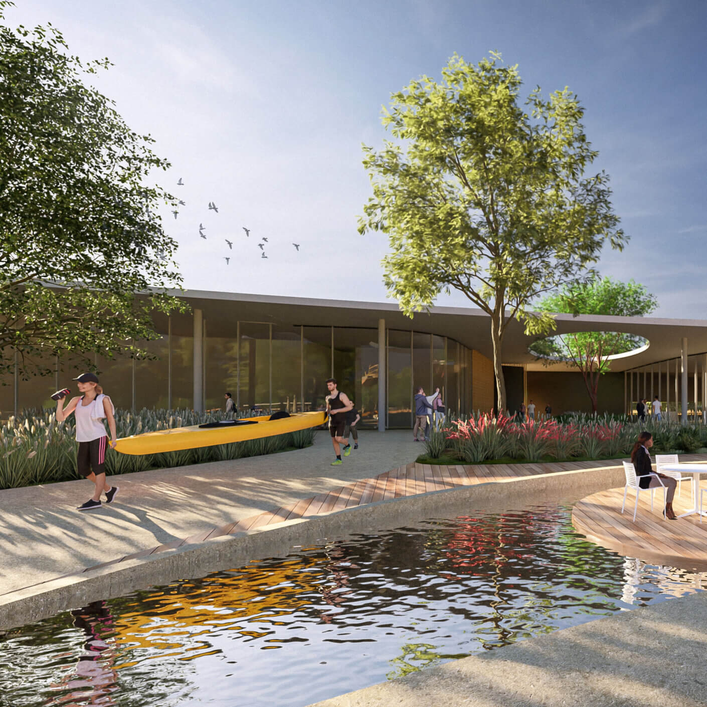 Modern outdoor plaza with trees and water, people carrying a kayak.