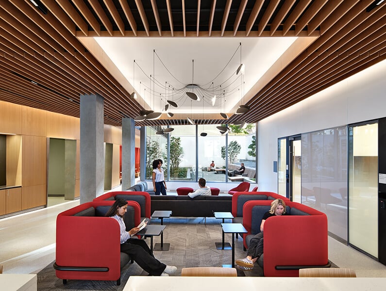 Student lounge with red seating and natural light.