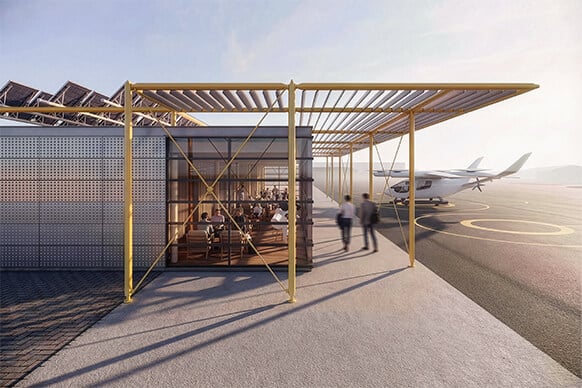 Exterior view of a facility with large windows and yellow structural elements, adjacent to an airport runway and aircraft.